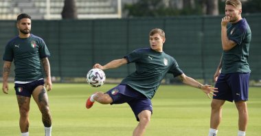 Italy's Lorenzo Insigne (L) and Ciro Immobile (R) look at Nicolo Barella as he controls the ball during a team training session in Rome, Italy, June 19, 2021. (AP Photo)