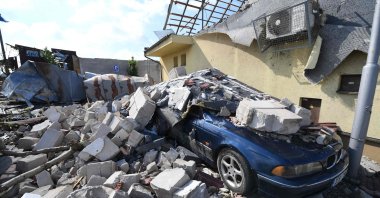 A car is consumed by the rubble of damaged houses after they were hit by a tornado, in the village of Moravska Nova Ves, some 60 kilometers (37 miles) south of Brno, South Moravia, Czech Republic, on June 25, 2021. (AFP Photo)