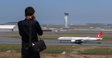 A plane spotter takes pictures of an airplane at Istanbul Airport, Istanbul, Turkey, June 25, 2021. (AA PHOTO)