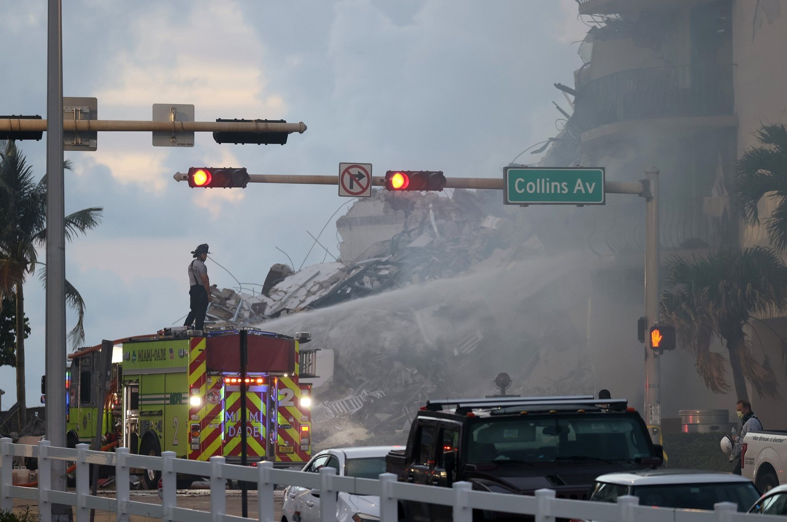Miami-Dade Fire Rescue personnel spray water on a fire in the partially collapsed 12-story Champlain Towers South condo building as search and rescue operations continue in Surfside, Florida, June 25, 2021. (AFP Photo)