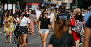 People walk in the streets of Madrid, many maskless as they are no longer required outdoors despite the ongoing COVID-19 pandemic, Madrid, Spain, June 26, 2021. (Reuters Photo)
