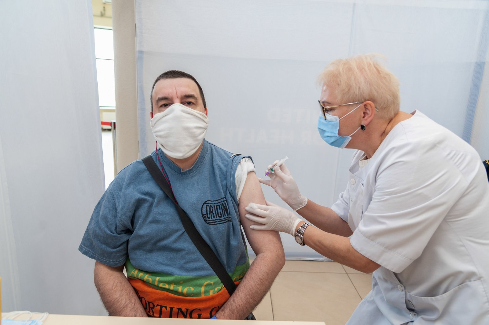 A healthcare worker administers a dose of Sinovac vaccine to a man at the Arena Lviv stadium, in Lviv, Ukraine, May 29, 2021. (Sipa USA via Reuters)
