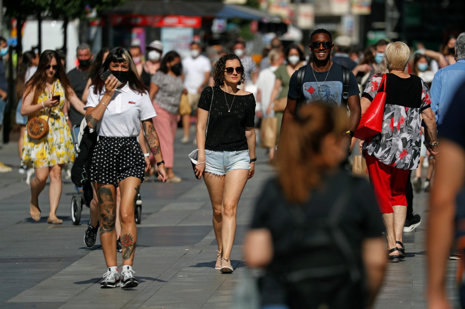 People walk in the streets of Madrid, many maskless as they are no longer required outdoors despite the ongoing COVID-19 pandemic, Madrid, Spain, June 26, 2021. (Reuters Photo)