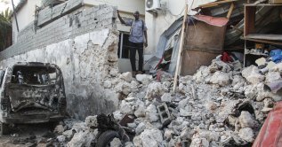 A hotel security guard stands by wreckage in the aftermath of an attack on the Afrik hotel in Mogadishu, Somalia, Feb. 1, 2021. (AP File Photo)