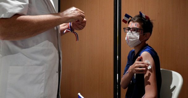 A French supporter receives a dose of the Pfizer COVID-19 vaccine during a vaccination drive at the Armand Peugeot Fan-zone, where fans watch the broadcast of the UEFA Euro 2020 Group F football match between France and Portugal in Poissy, outside Paris, France, on June 23, 2021. (AFP Photo)
