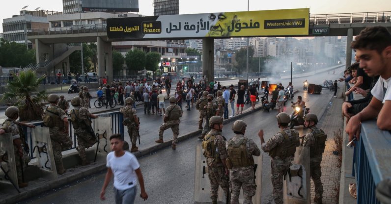 Lebanese forces watch anti-government protesters burn waste bins to block a highway that leads to the airport during a protest in Beirut, Lebanon, June 26, 2021. (EPA Photo)