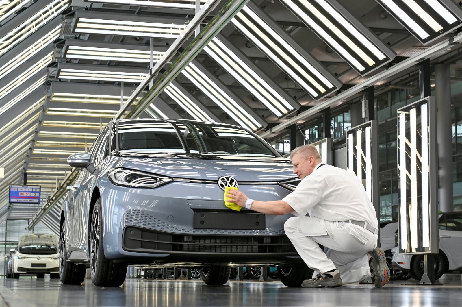 Technicians work in the final inspection line of German carmaker Volkswagen's electric ID. 3 car in Dresden, Germany, June 8, 2021. (Reuters Photo)