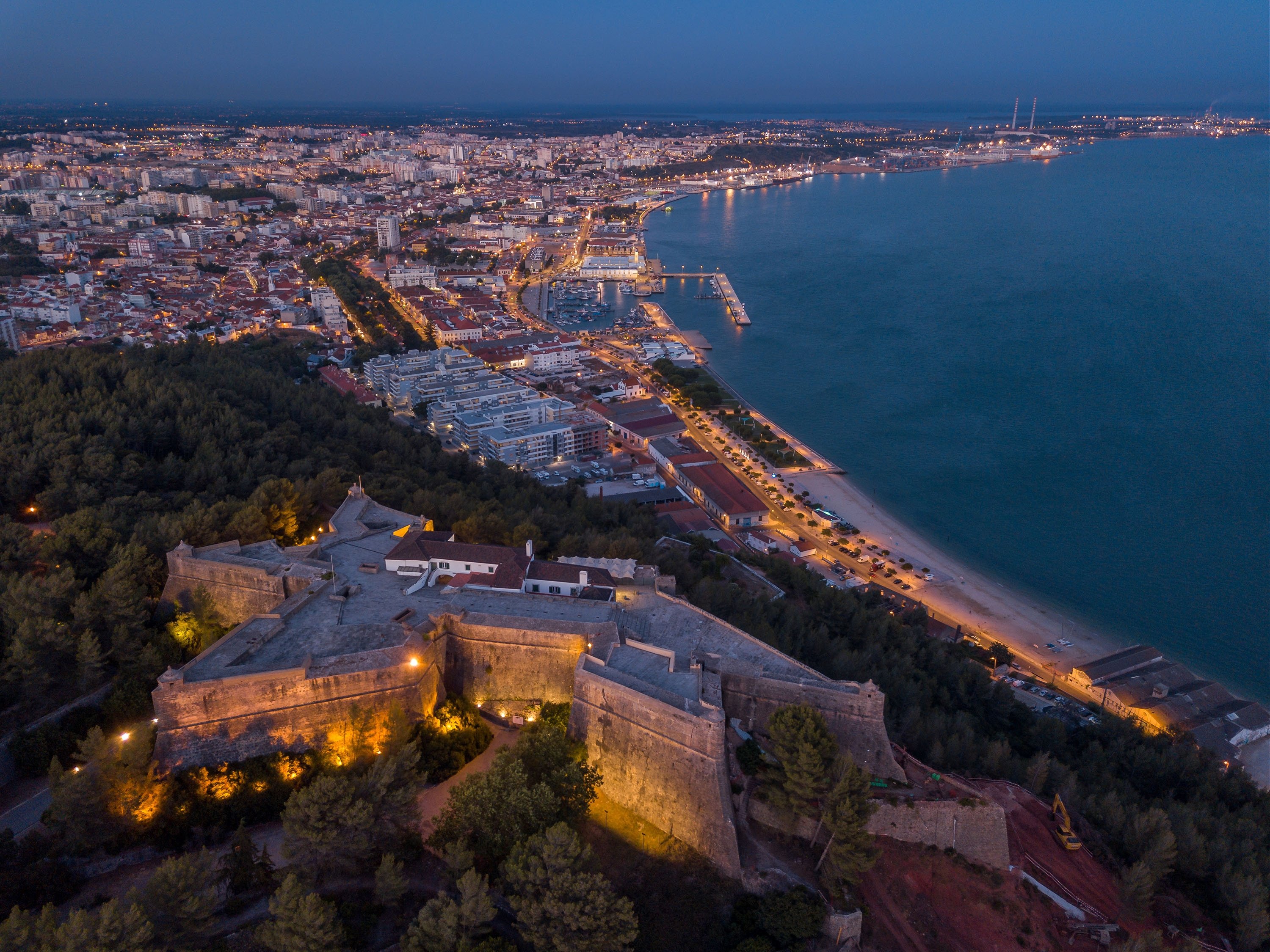 An aerial nighttime view shows lights brighten the city of Setubal, Portugal. (Shutterstock Photo)