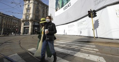 Women wearing sanitary masks walk in downtown Milan, Italy, Feb. 24, 2020. (AP Photo)
