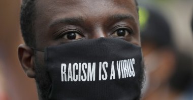 A protester wears a face mask in front of the U.S. embassy, during the Black Lives Matter protest rally in London, June 7, 2020. (AP Photo)