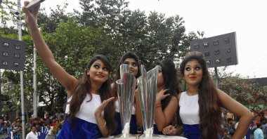 Models take a selfie next to the World Twenty20 trophies after they arrived in Kolkata, India, Feb. 24, 2016. (Reuters Photo)