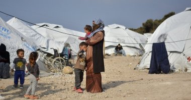 A woman holds a baby at Karatepe refugee camp, on the eastern Aegean island of Lesbos, Greece, March 29, 2021. (AP Photo)