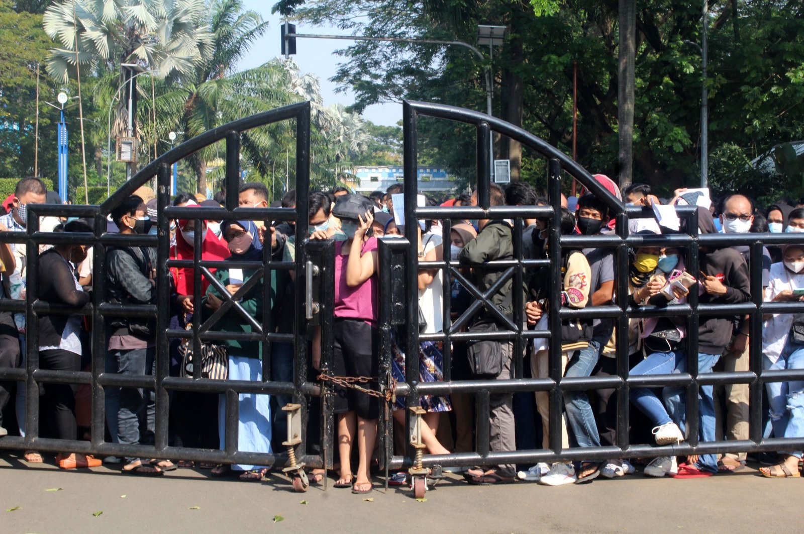 Residents gather at the gate of a COVID-19 vaccination centre in Tangerang, in the suburbs of Jakarta, Indonesia, June 29, 2021. (AFP Photo)