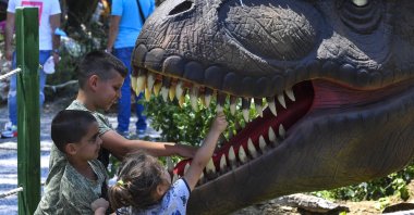 Children play with and between the replicas of dinosaurs in the newly opened Dino Park in the zoo in Skopje, Republic of North Macedonia, June 5, 2021. (EPA Photo)