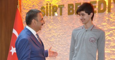 Governor and Deputy Mayor of Siirt Osman Hacıbektaşoğlu (L) congratulates Syrian student Dlyar Safo at a ceremony at the Siirt Municipality, Siirt, Turkey, on June 30, 2021. (IHA Photo)