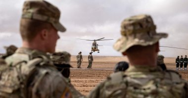 U.S. military personnel look on as CH-47 Chinook military helicopters take off during the "African Lion" military exercise in the Tan-Tan region in southwestern Morocco, June 18, 2021. (AFP Photo)