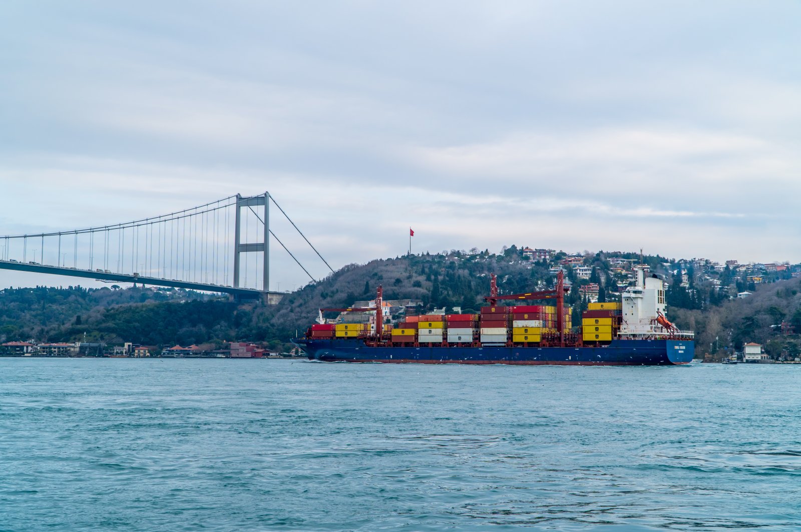 A container ship sails through Bosporus passing under the Fatih Sultan Mehmet Bridge, in Istanbul, Turkey, Feb. 19, 2021. (Shutterstock Photo)