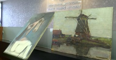 The painting "Woman's Head" by Pablo Picasso, stolen from Greece's National Gallery in 2012, drops to the floor during a presentation to the media at the Ministry of Citizen Protection in Athens, Greece, June 29, 2021. (Reuters Photo)