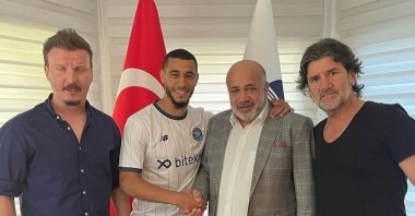 Moroccan midfielder Younes Belhanda (C-L) shakes hands with Adana Demirspor President Murat Sancak (C-R) at the club headquarters in Adana, Turkey, July 1, 2021 (IHA Photo)