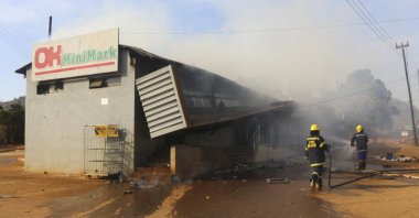 Firefighters extinguish a fire at a supermarket in Manzini, Eswatini, on June 30, 2021. (AFP Photo)