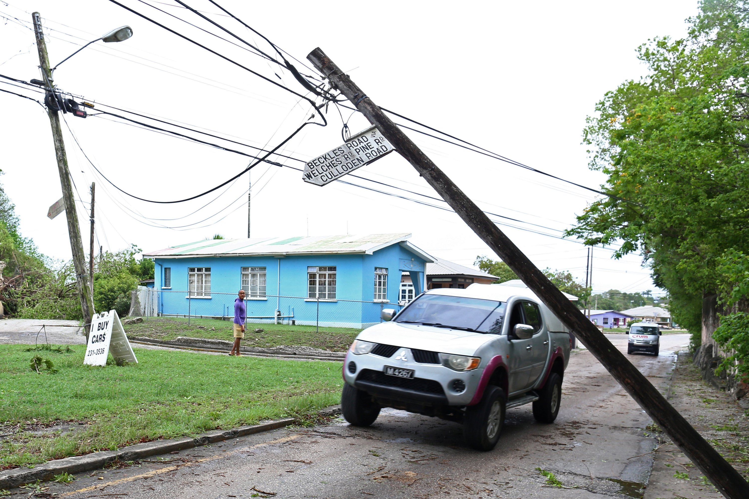 A vehicle maneuvres around a fallen pole after strong winds of Hurricane Elsa passed St. Michael, Barbados, July 2, 2021.  (Reuters Photo)