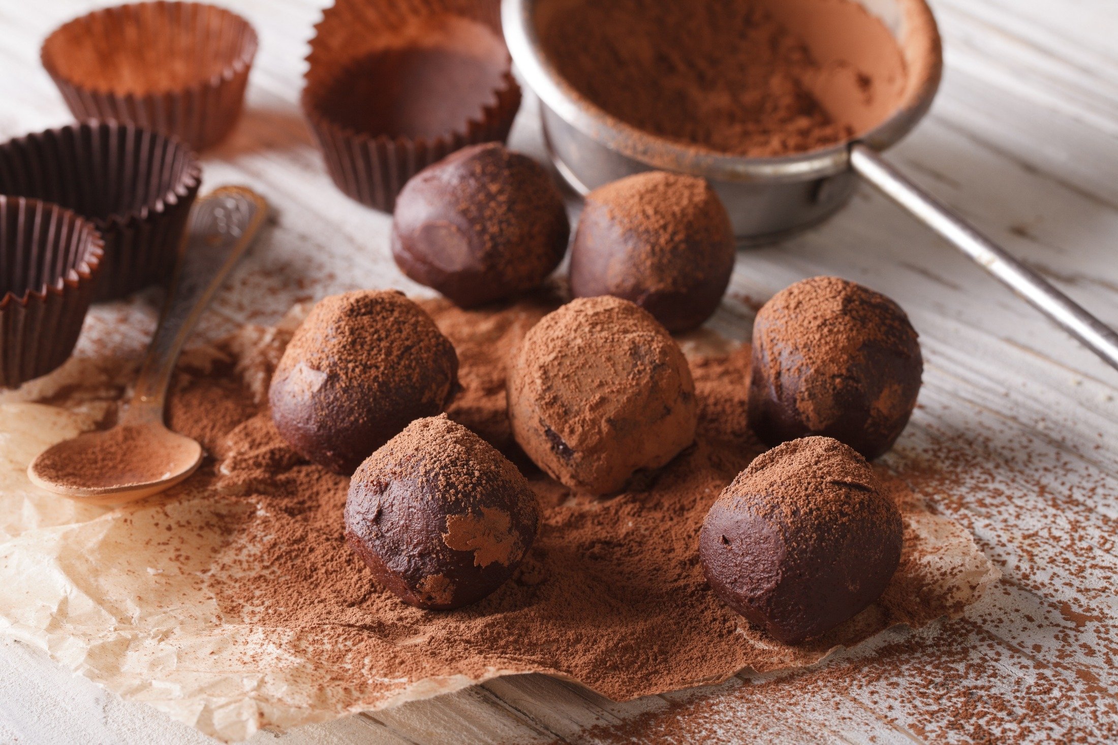 A batch of chocolate truffles amongst other ingredients on a table. (Shutterstock Photo)