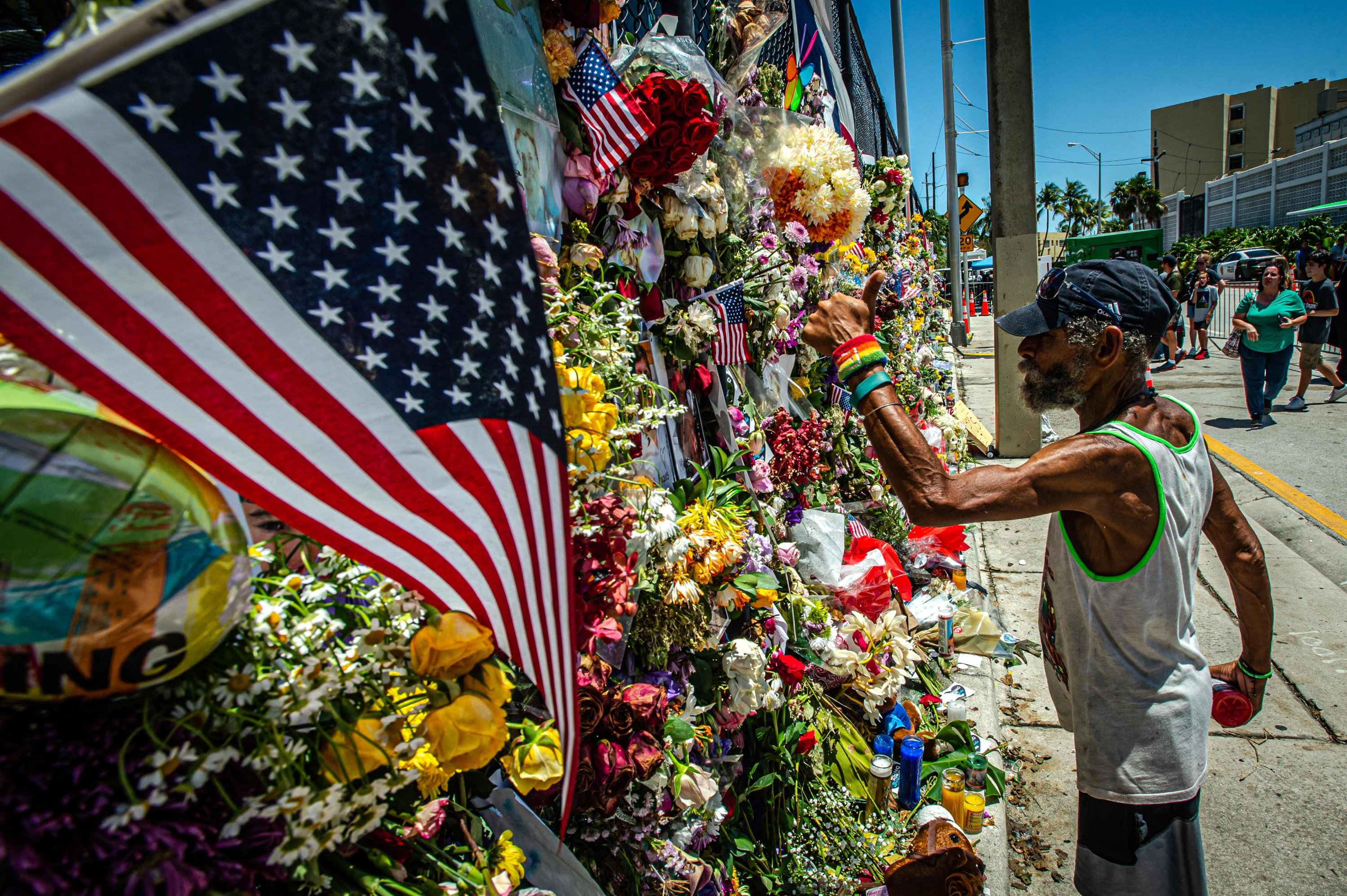 A man adds flowers to a memorial full of pictures of those missing from the partially collapsed 12-story Champlain Towers South condo building in Surfside, Florida, U.S., July 3, 2021. (AFP Photo)