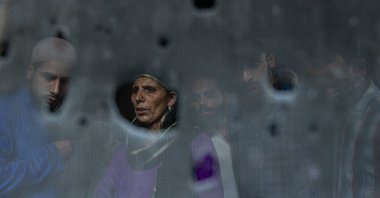 Kashmiri villagers are seen through the bullet-ridden iron mesh of a window of the residential house where suspected rebels were taking refuge, after a gunfight in Pulwama, south of Srinagar, Indian controlled Kashmir, Friday, July 2, 2021. (AP Photo)