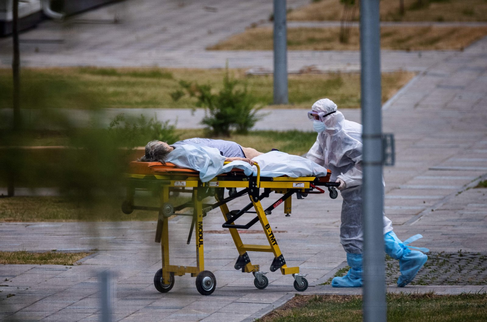 A medic wheels a woman into a hospital where patients infected with the coronavirus are being treated in the settlement of Kommunarka, outside Moscow, Russia, June 30, 2021. (AFP Photo)