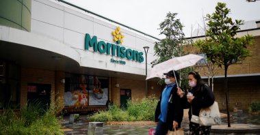 People walk past a Morrisons supermarket in Stratford, east London, June 21, 2021. (AFP Photo)