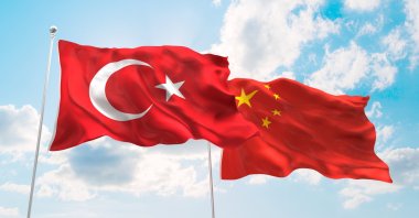 The flags of Turkey and China wave against a blue spring sky. (Shutterstock Photo)