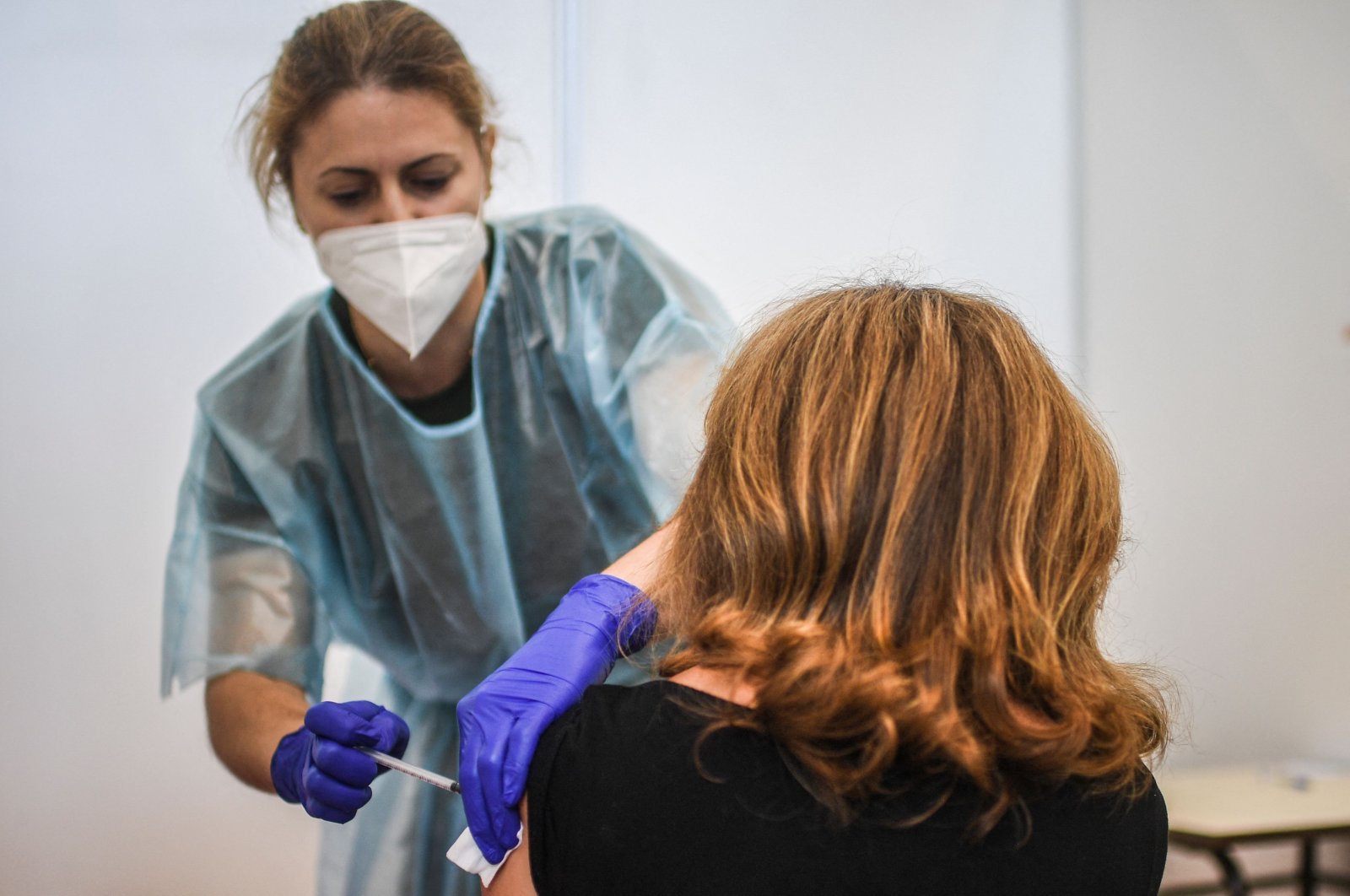A healthcare worker administers a dose of a COVID-19 vaccine to a woman at a vaccination center in Lisbon, Portugal, July 2, 2021. (AFP Photo)