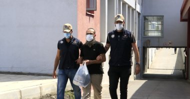 Police officers escort Daesh terrorist Irfan Ç. (C) in Adana province, July 6, 2021. (IHA Photo)