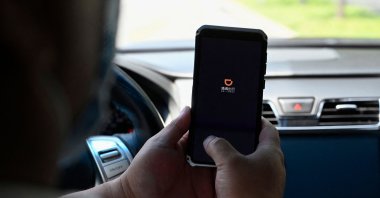A driver opening the Didi Chuxing ride-hailing app on his smartphone in Beijing, China, July 2, 2021. (AFP Photo)