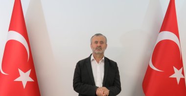 Orhan Inandı poses between two Turkish flags in this photo handed out to the media after he was brought to Turkey, July 5, 2021. (AA PHOTO)