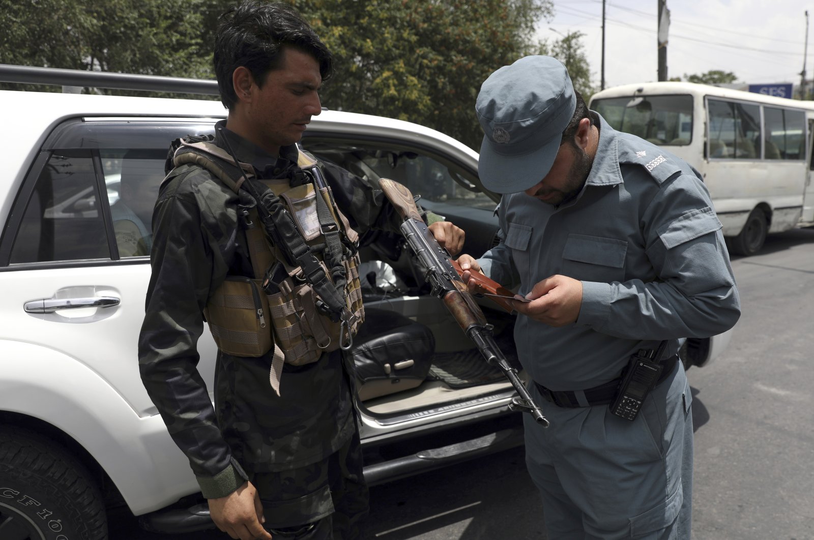 An Afghan police officer checks the documentation of a gun owner, at a temporary checkpoint in Kabul, Afghanistan, July 4, 2021. (AP Photo)