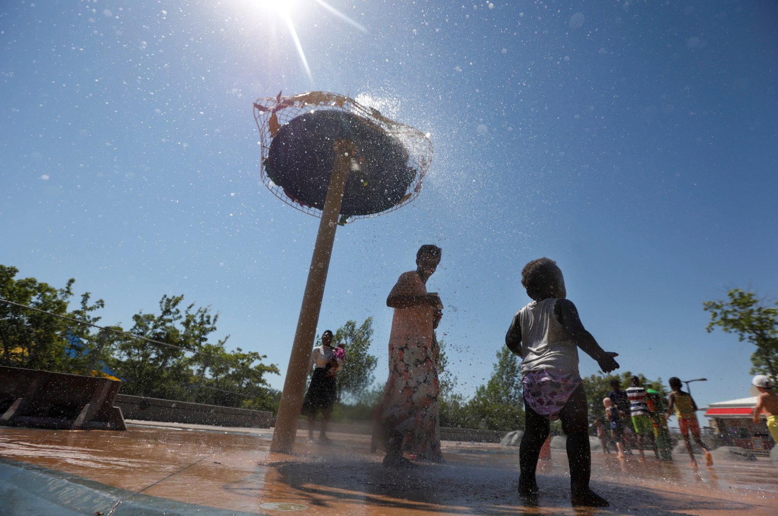 Kids play in water to cool off during the scorching weather of a heat wave at a River Landing splash park in Saskatoon, Saskatchewan, Canada, July 2, 2021. (Reuters Photo)