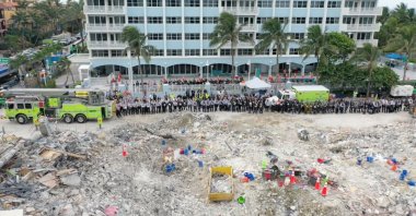 Members of the search and rescue team stand during a moment of silence in front of the rubble of the collapsed Champlain Towers South building in Surfside, Florida, U.S. July 7, 2021, (Reuters Photo)