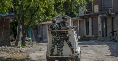 Indian paramilitary soldiers stand guard on an armored vehicle as they move toward the site of a gunfight in Pulwama, south of Srinagar, Indian-controlled Kashmir, July 2, 2021. (AP Photo)