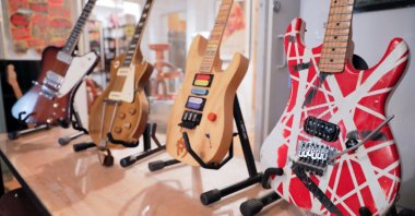 (L-R) A Gibson Firebird guitar that belonged to Allen Collins of Lynyrd Skynyrd, a single owner 1952 Gibson Les Paul gold top, Jason Becker's "Numbers" guitar and Eddie Van Halen's Kramer Stryper guitar are seen on stands ahead of the "Century of Music" auction held at Guernsey's auction house in New York City, New York, U.S., July 6, 2021. (REUTERS Photo)