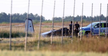 Police officers investigate the site where a small aircraft crashed at Orebro Airport, Orebro, Sweden, July 8, 2021. (Reuters Photo)