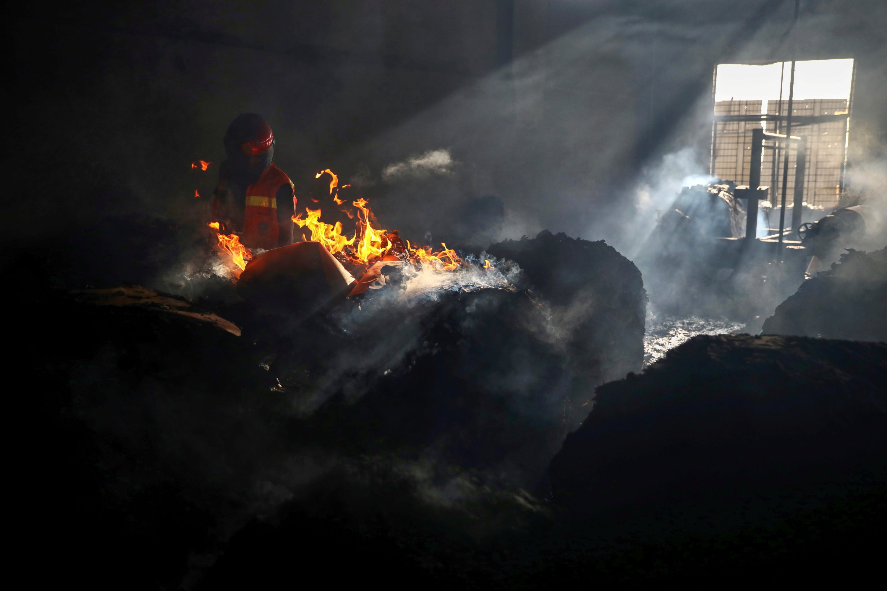 A firefighter tries to extinguish fire inside the building after a fire broke out at a factory named Hashem Foods Ltd. in Rupganj of Narayanganj district, on the outskirts of Dhaka, Bangladesh, July 9, 2021. (Reuters Photo)