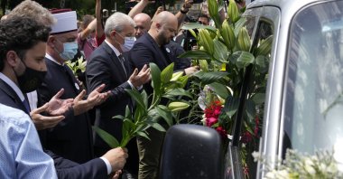 Dignitaries pay respect in front of a motorcade carrying 19 identified bodies of victims that will be buried in Srebrenica on Sunday, Sarajevo, Bosnia, July 9, 2021. (AP Photo)