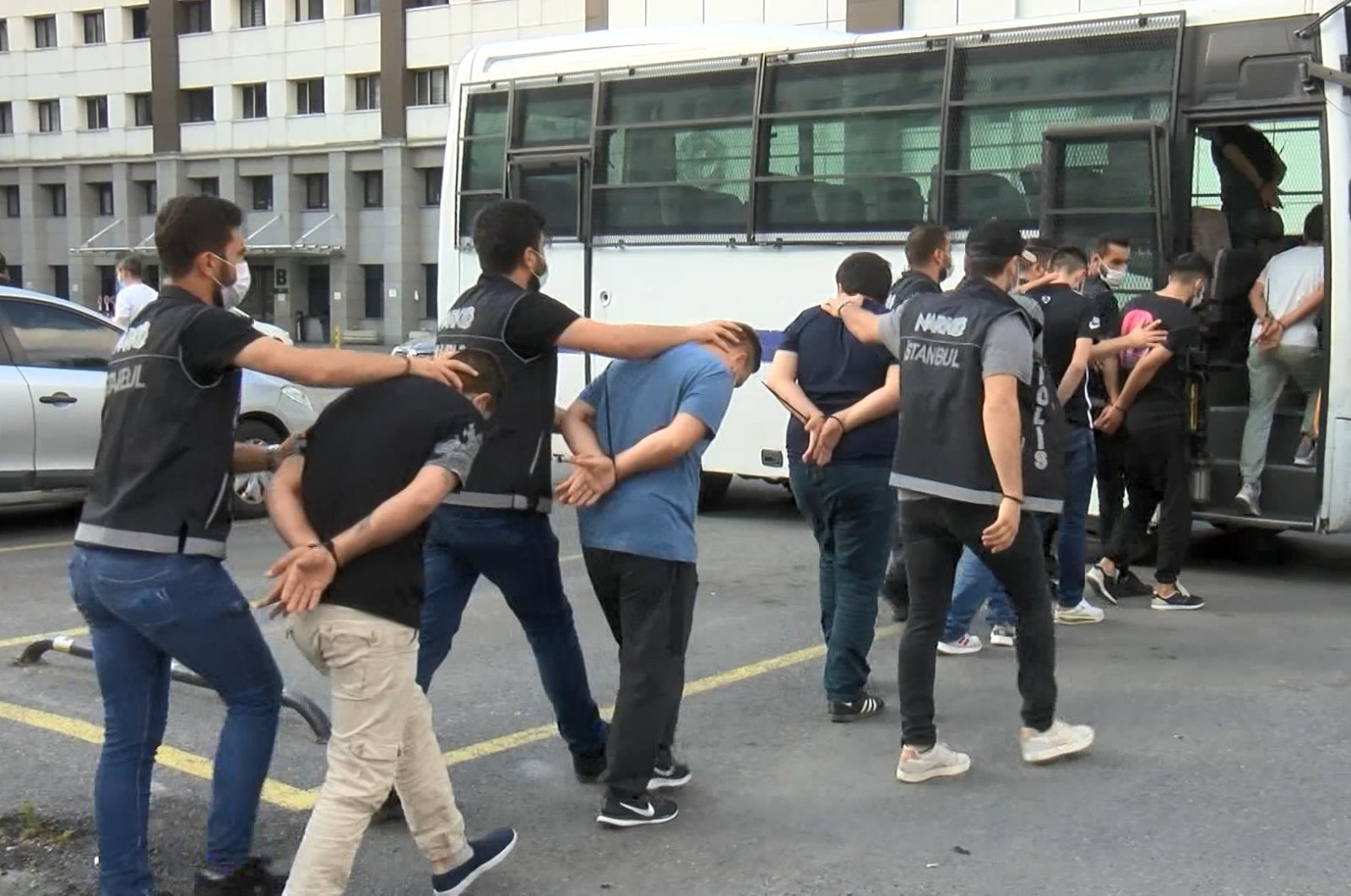 Police officers escort nabbed drug suspects to a bus to transfer them to the court, in Istanbul, Turkey, July 9, 2021. (DHA Photo)