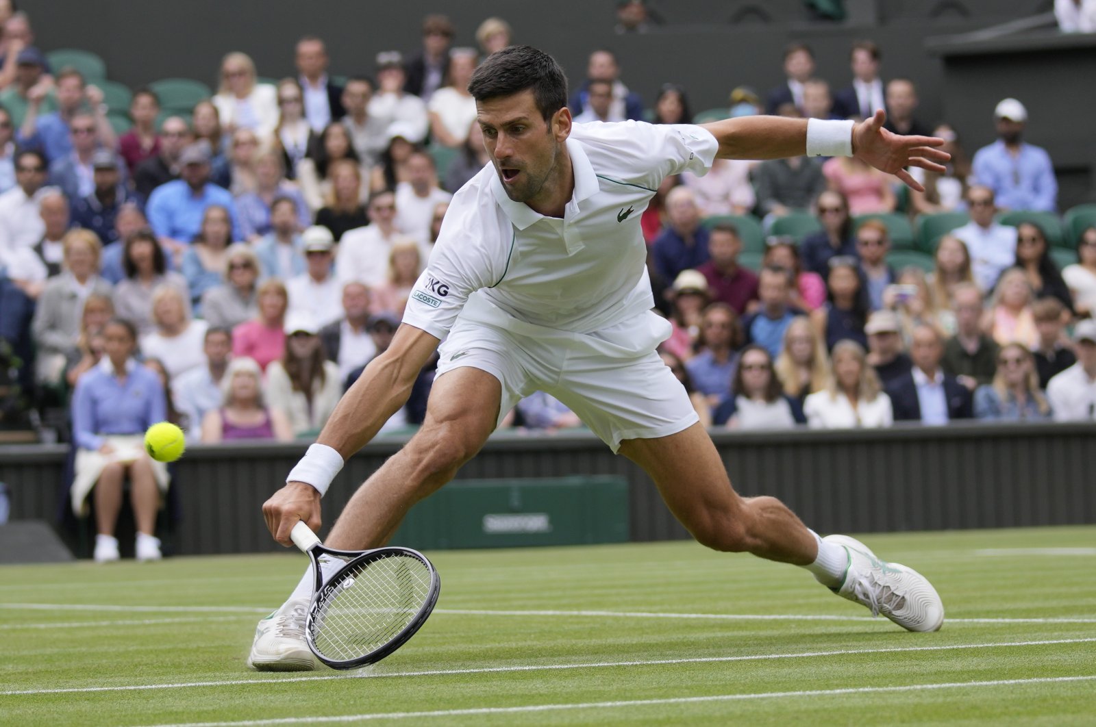 Serbia's Novak Djokovic plays a return to Hungary's Marton Fucsovics during the Wimbledon men's singles quarterfinals match in London, England, July 7, 2021. (AP Photo)