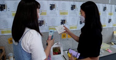 Women take a look at items at a feces currency market at Ulsan National Institute of Science and Technology (UNIST) in Ulsan, South Korea, July 6, 2021. (Reuters Photo)
