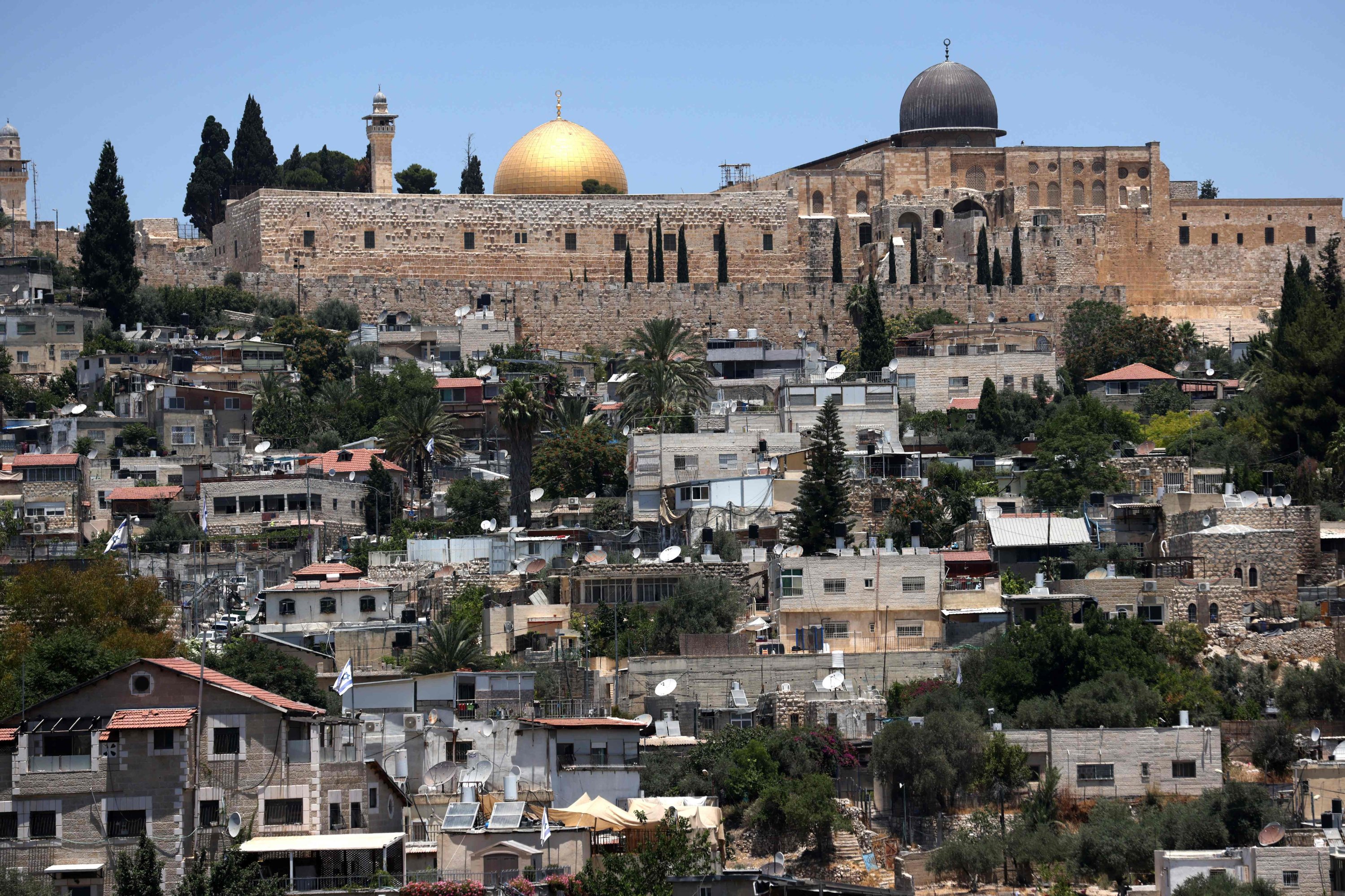 The domes of the Dome of the Rock (L) and the Al-Aqsa (R) mosques behind the walls of Jerusalem's Old City, in Silwan, East Jerusalem, July 2, 2021. (AFP Photo)