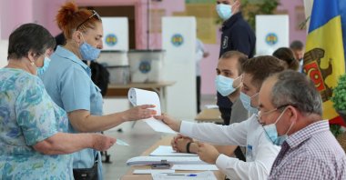 People queue to receive ballots during a vote at a snap parliamentary election, in Chisinau, Moldova July 11, 2021. (Reuters Photo)