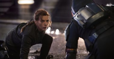 Scarlett Johansson kneels during an action scene in the film "Black Widow." (Disney via AP)