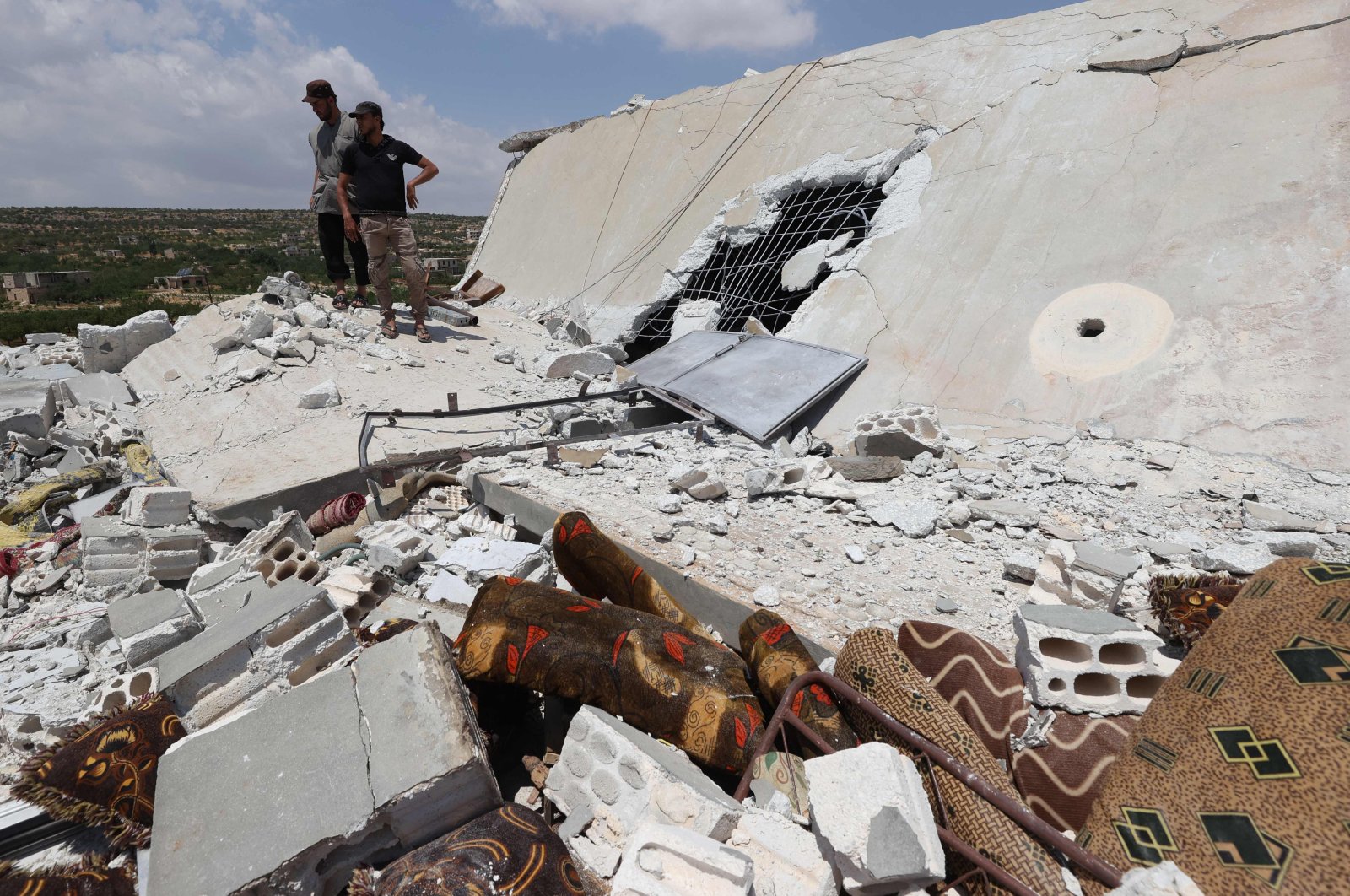 People inspect a damaged house destroyed by a Russian missile attack in the Jabal al-Zawiya region in the south of Syria's rebel-held Idlib province, July 4, 2021. (Photo by Omar Haj Kadour/AFP)